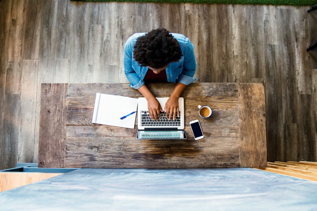 Overhead view of a woman using a computer whilst working/ studying in a modern looking room. Los Angeles, America. October 2016